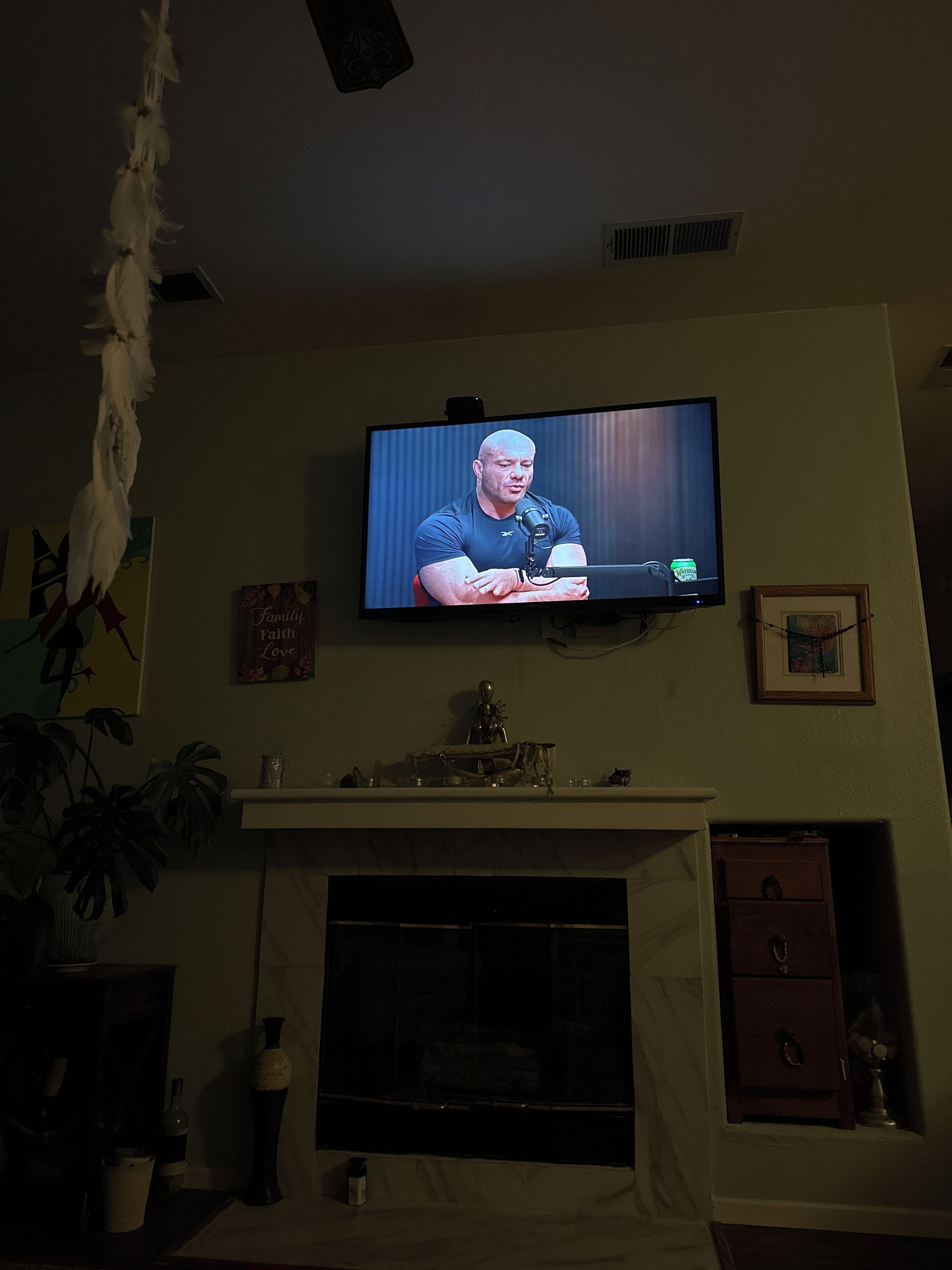 Een televisie aan de muur met daarop een persoon.