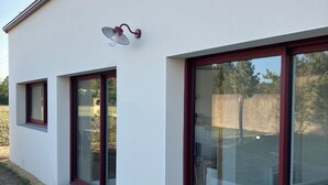 A modern building with large glass sliding doors and a small window.