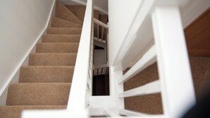 A staircase with beige carpeted steps and white railings. - Spacious 3 bed  town house in Bristol. (Bristol)