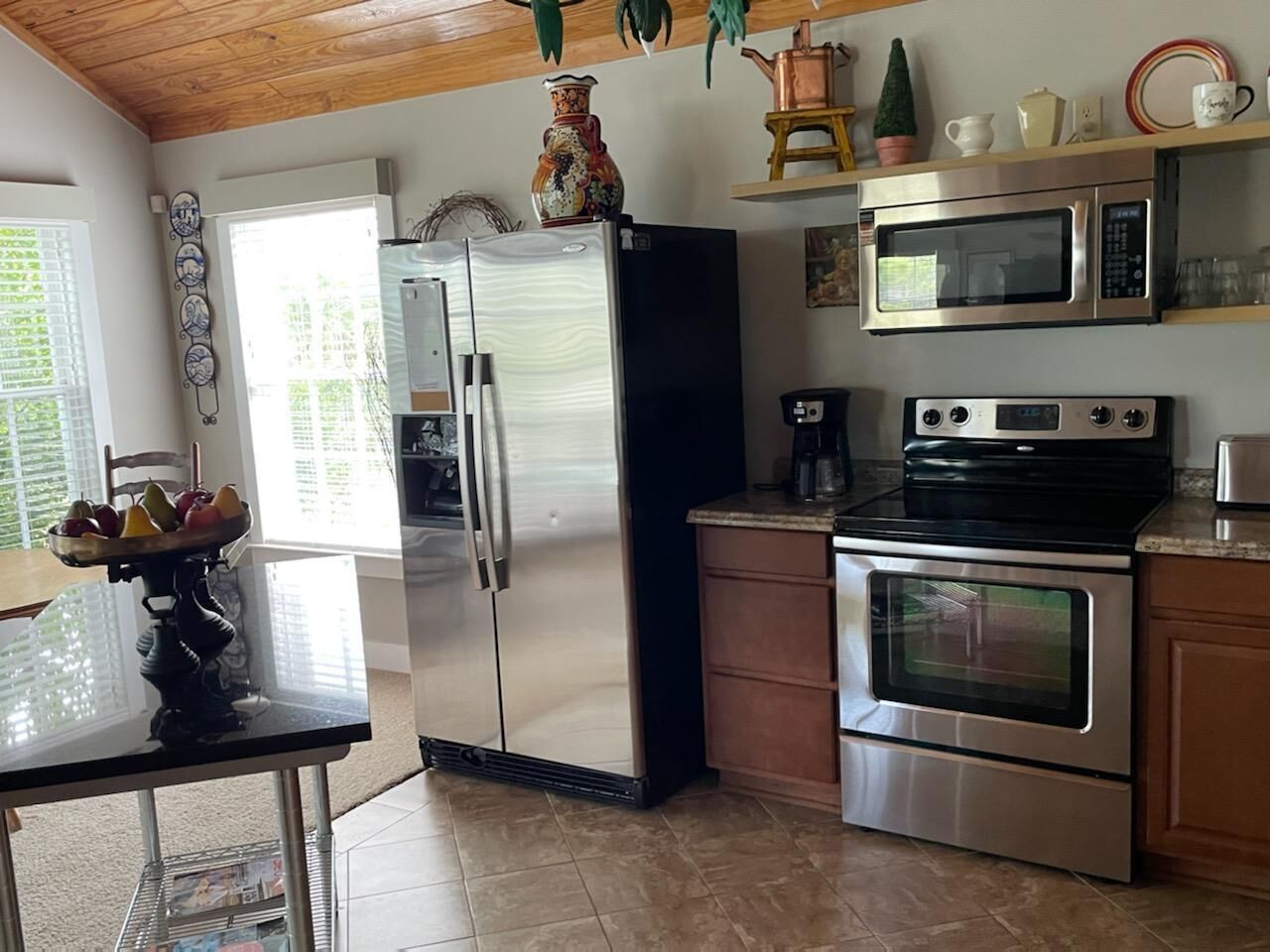 A kitchen with a stainless steel refrigerator, oven, and microwave.