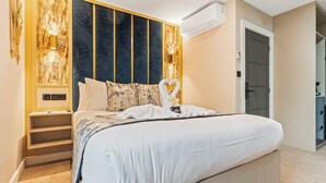 Un dormitorio moderno con una cama grande, una estantería empotrada y un aire acondicionado de pared.