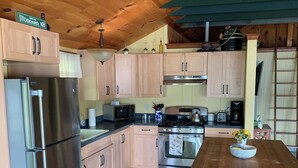 Une cuisine moderne avec des meubles en bois, des appareils en acier inoxydable et un îlot central doté de tabourets.