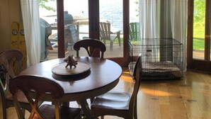 A wooden dining table with chairs, a small table lamp, and a bird figurine.