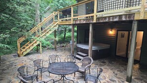 A stone patio with wicker chairs and a hot tub. - The Getaway at Wintergreen Resort (Wintergreen Resort)