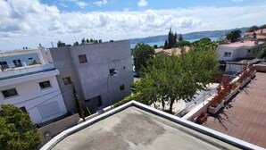 A rooftop terrace with a view of surrounding buildings and a distant body of water. - Lisboa belem   elite domum (Lisbon)