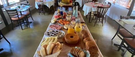 A long table with various food items and a dog in a basket.