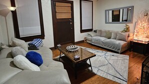A living room with a sofa, a coffee table, and a fireplace. - 2 Blocks to UF Campus in Midtown & 10min Walk to Ben Griffin Stadium, Free Wi-Fi (Gainesville)