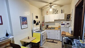 A compact kitchen with white cabinets, a gas stove, and a ceiling fan. - 2 Blocks to UF Campus in Midtown & 10min Walk to Ben Griffin Stadium, Free Wi-Fi (Gainesville)