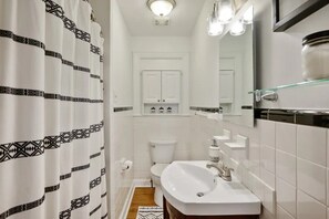 Bathroom features a white sink, toilet, and glass shower enclosure.