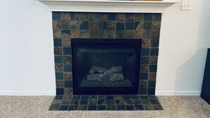 Una chimenea con revestimiento de piedra y un letrero que dice 'CHEERS' encima.