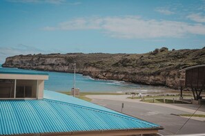 A coastal building with a blue roof overlooking a cliff and ocean. - Surf break - Beachfront Port Campbell (Port Campbell)