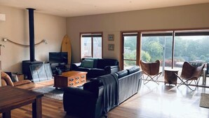 Un salón espacioso con chimenea, un sofá, una mesa de centro y un televisor.