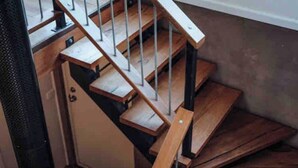 A wooden staircase with metal railings leading to a landing. - Woodlands - Secluded Rustic Cottage Near Great Ocean Road (Port Campbell)