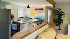 Une cuisine dotée d’un plan de travail en bois, d’un réfrigérateur et d’un coin repas avec une table et des chaises.