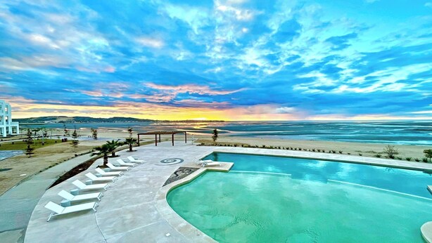 A pool with lounge chairs and a view of the ocean at sunset. - Blue House LV 2-4 Costa Divina by Kivoya (Puerto Peñasco)