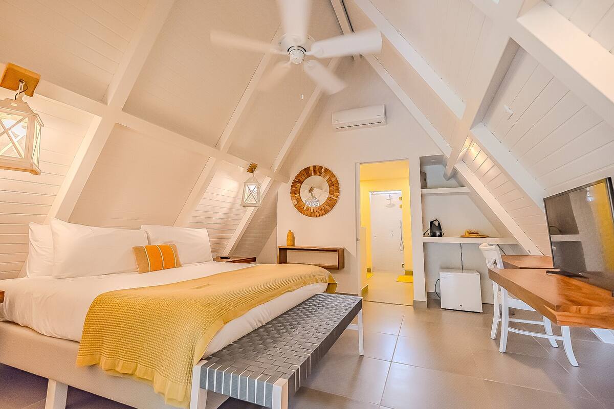 Une chambre à coucher comprenant un lit, une table de chevet et un espace bureau.
