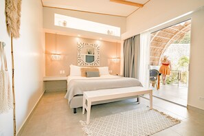 A bedroom with a bed, bedside tables, a mirror, and a bench. - Les Voiles Blanches Tamarindo  (Tamarindo)