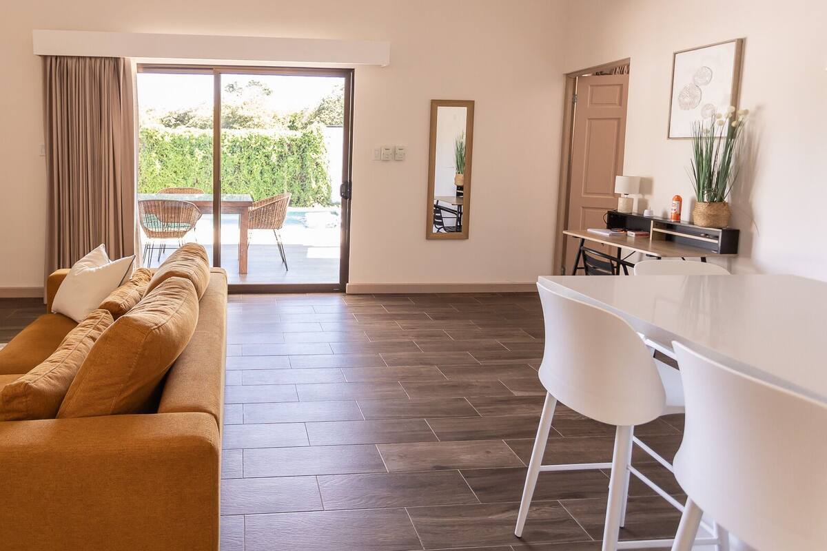 Un salon moderne comprenant un canapé, une table à manger et un coin cuisine.