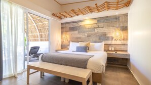 Un dormitorio con cama, banco y una lámpara fijada a la pared.