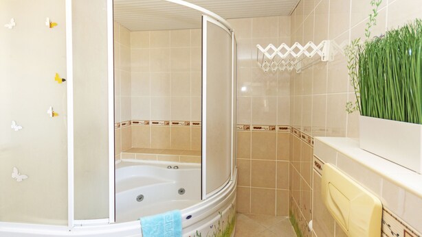 A bathroom with a bathtub, a shower, and a toilet. There are decorative tiles and a towel rack. - Paradise Town Villa Camilla (Serik)