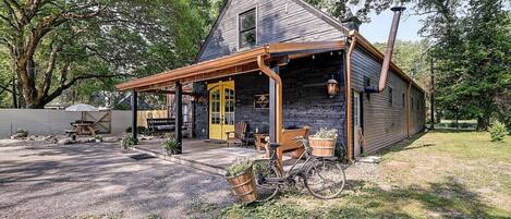 A rustic cabin with a porch, a bicycle, and outdoor seating.