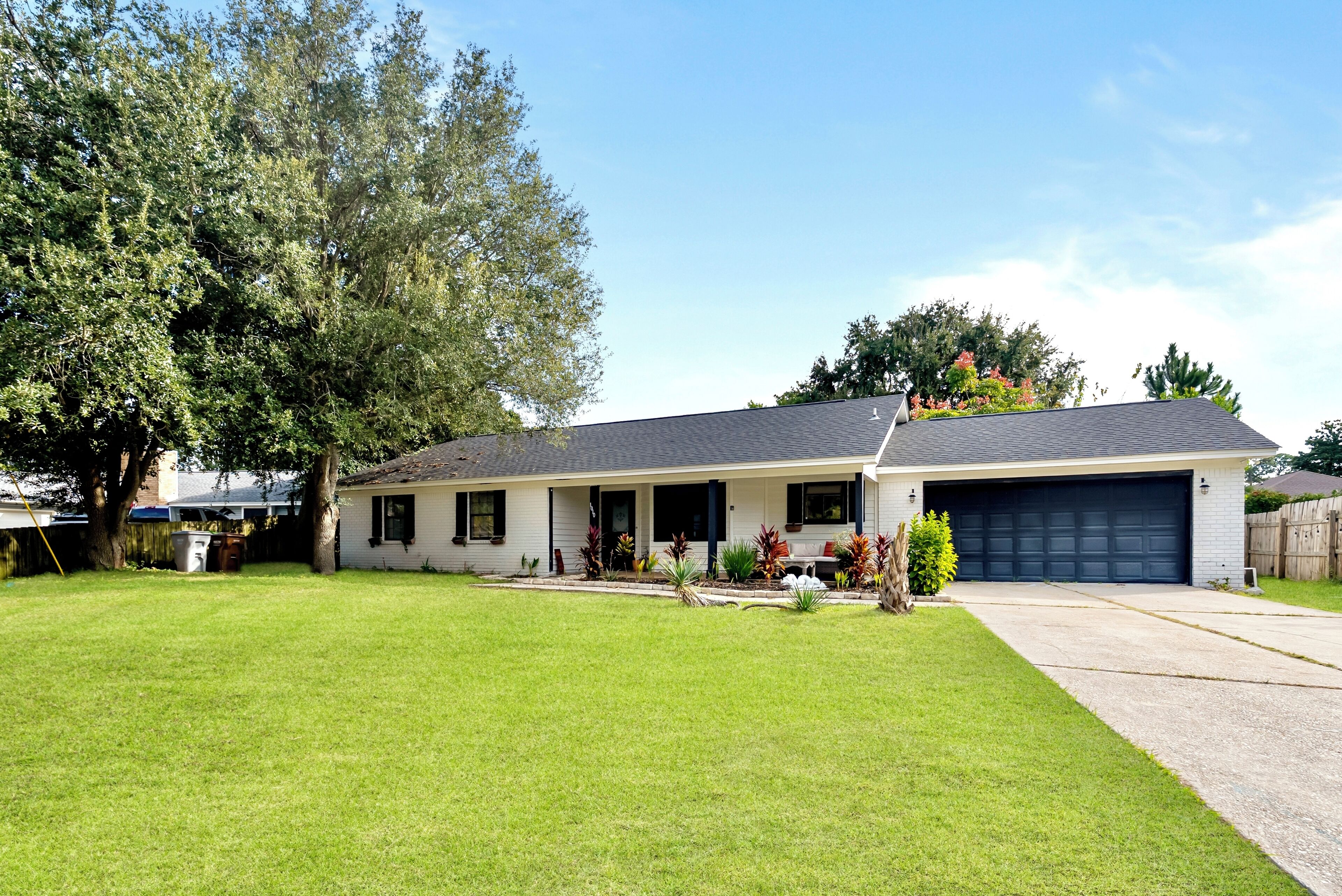 A single-story house with a front porch, a garage, and a well-maintained lawn.