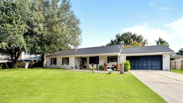 A single-story house with a front porch, a garage, and a well-maintained lawn.