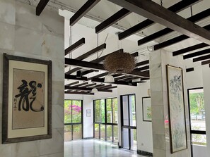 Experience the spacious room with high ceilings, large windows, and beautiful artwork on display.