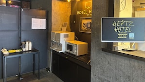 A hotel reception area with a digital display, a sound system, and a wall-mounted clock. - HERTZ Hotel (Seoul)