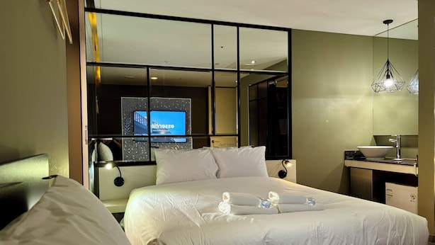 A hotel room with a bed, a desk with a sink, a television, and a mirror. - HERTZ Hotel (Seoul)
