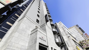 A high-rise hotel with a modern architectural design, featuring a prominent 'HOTEL HERTZ' sign on the facade. - HERTZ Hotel (Seoul)