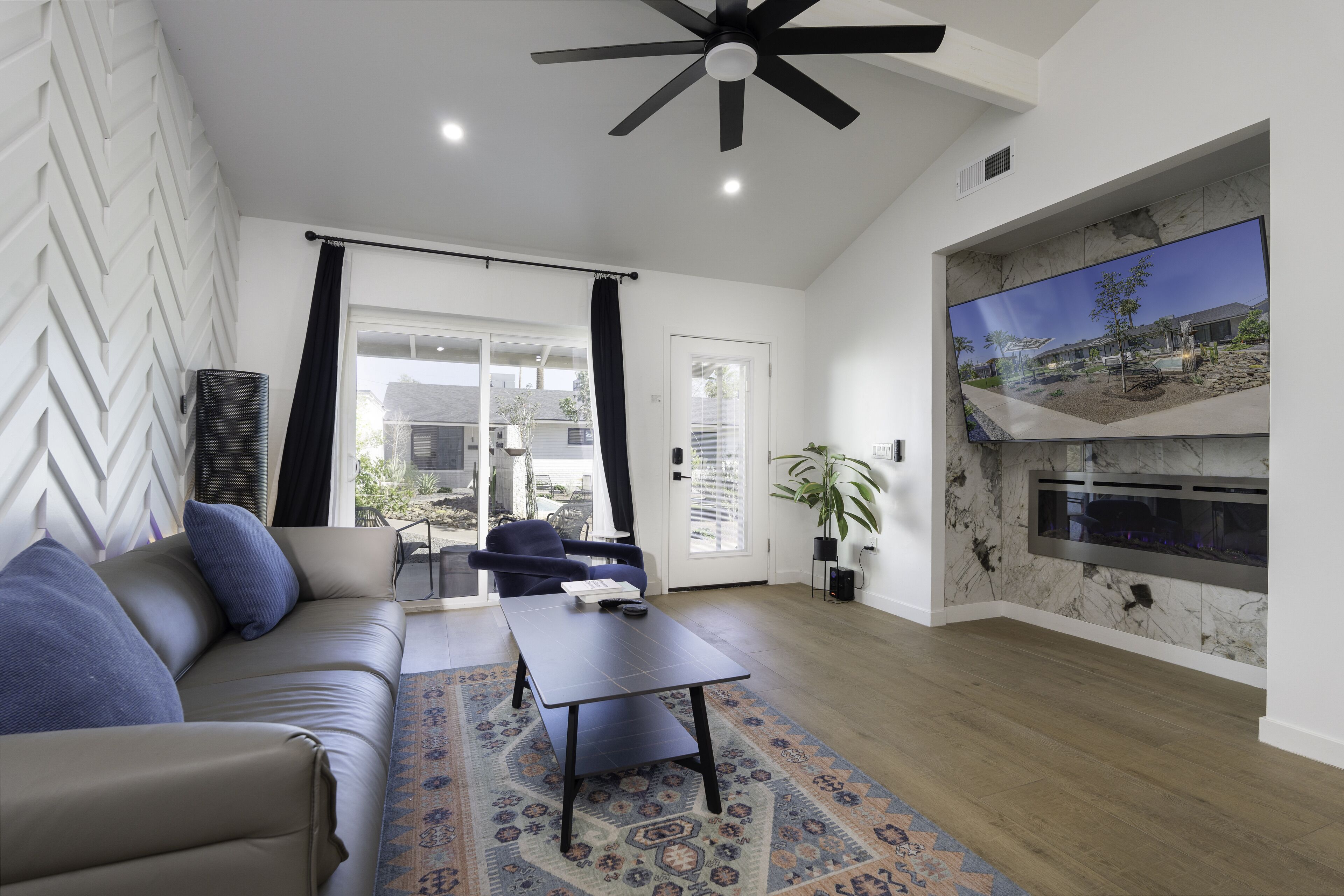 A modern living room with a sofa, coffee table, and a fireplace.