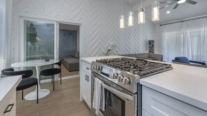 A modern kitchen with a central island, stainless steel appliances, and pendant lighting. - Ash & Ko Boutique Lodging (Phoenix)