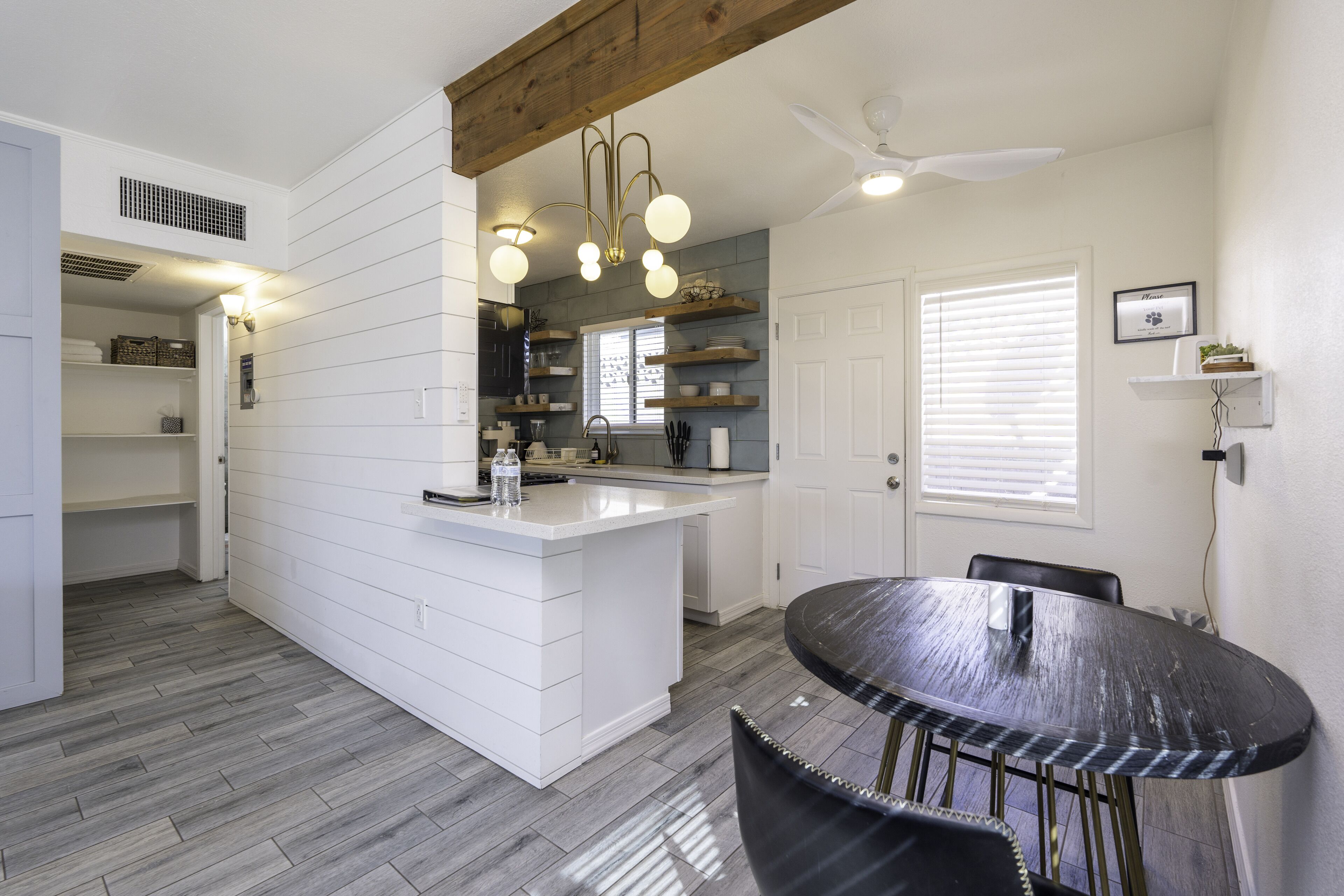 A modern kitchen with white cabinetry, a central island, and pendant lighting.