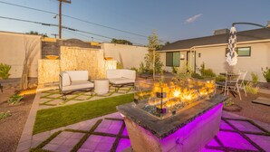 A backyard with a fire pit, outdoor seating, and a well-maintained lawn. - Ash & Ko Boutique Lodging (Phoenix)