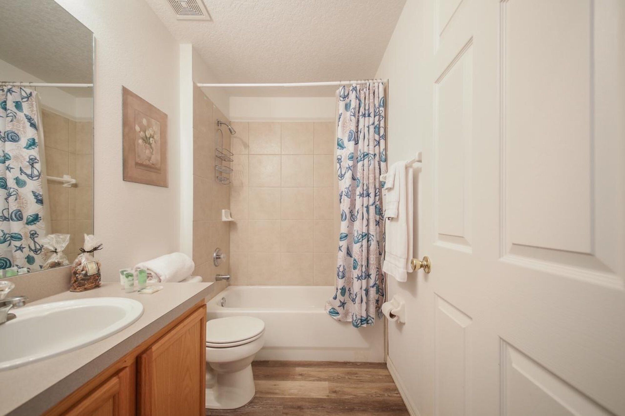 A bathroom with a sink, toilet, and shower.