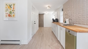Una cucina moderna con mobili bianchi, un piano di lavoro in legno e una lavastoviglie.