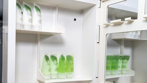A refrigerator with shelves containing bottles and containers. - Afueras Del Mar Container #1 (Lano Los Patos)