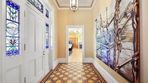 A hallway with a patterned floor, a large abstract painting, and stained glass windows. - Cornhill - Merrijig - Sleeps 12 (Merrijig)
