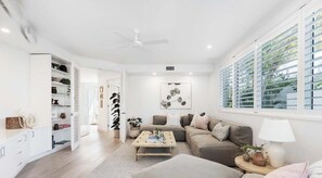 Un salon moderne avec un canapé, une table basse et un ventilateur de plafond.