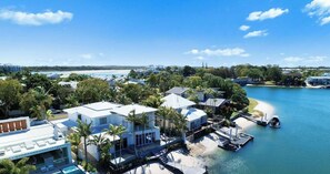 Une propriété située sur la côte, dotée d’une architecture moderne, d’un quai et offrant une vue sur la plage.