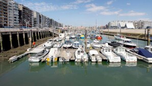 A marina with boats docked, a bridge, and buildings in the background. - Amuzee with parking & lateral sea view by Interhome (Blankenberge)
