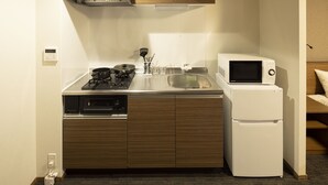 A compact kitchen with a stove, microwave, sink, and dishwasher. - Coruscant Hotel Nagasaki Station 3 (Nagasaki)