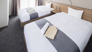 A hotel room with two beds, a wooden headboard, a small bedside table, and a carpeted floor. - Coruscant Hotel Nagasaki Station 3 (Nagasaki)