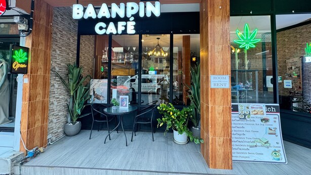 De buitenkant van Baappin Cafe, met een bord waarop kamer te huur staat en een menubord zichtbaar door het raam.