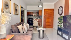 A modern living room with a sofa, coffee table, and a TV stand.
