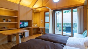 Una habitación con techo de madera, una cama, un escritorio, un televisor y un baño con ducha.