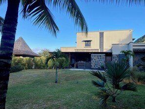 A modern house with a stone facade, a sloped roof, and a well-maintained lawn. - Villa Contemporaine - Côte Ouest (Rivière Noire)