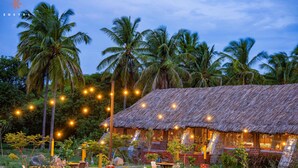 A rustic thatched-roof building with outdoor seating and string lights. - Zostel Hampi (Gangavathi) (Gangavathi)