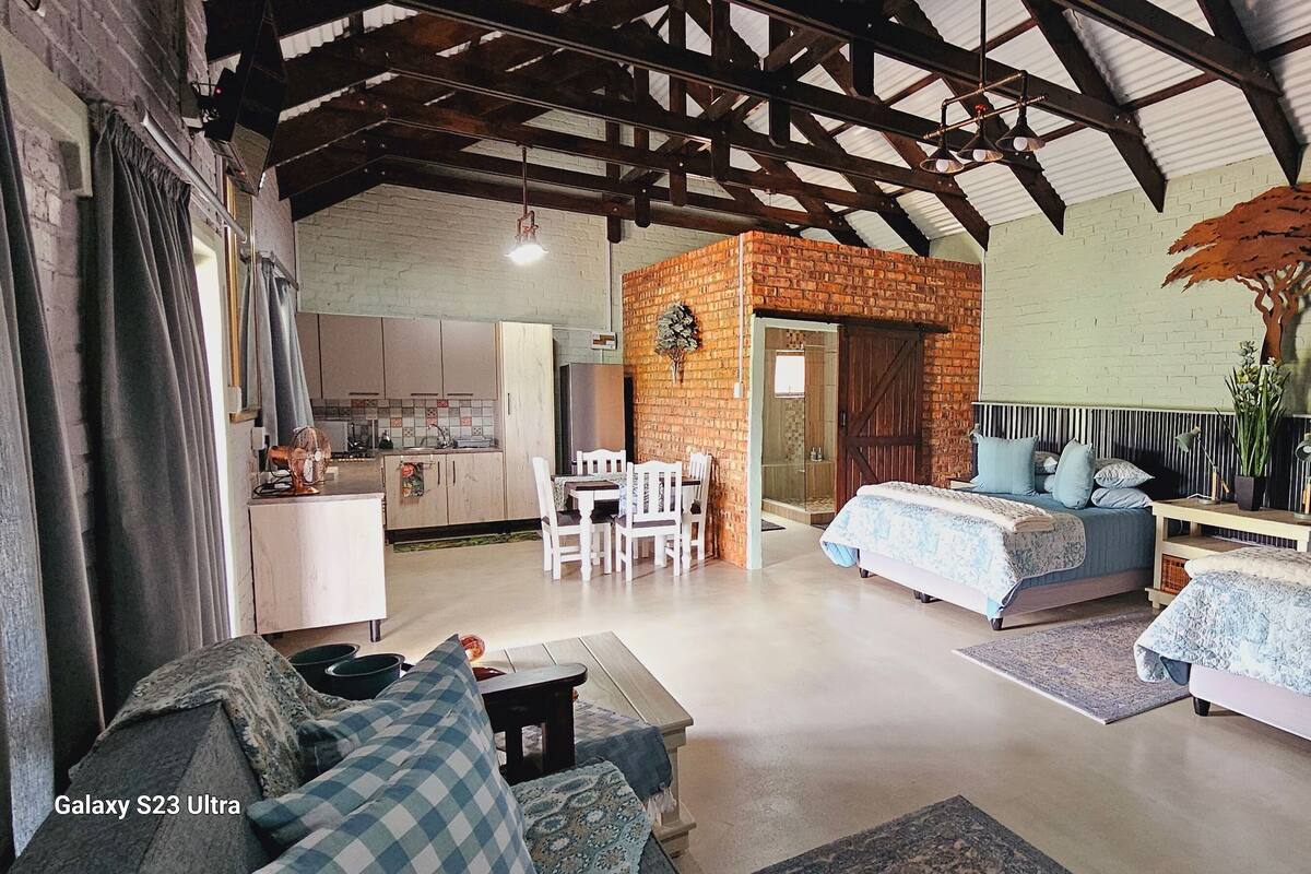 A spacious room with two beds, a dining area, and a kitchen.